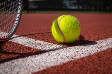 Tennis ball, racket and line on an outdoor court