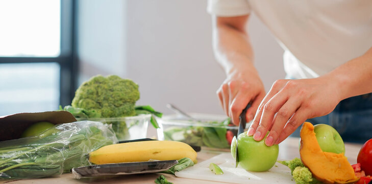 close up man hand using knife to cut vegetables on board and preparing food  for healthy living concept