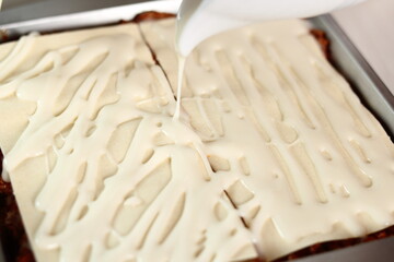 Pouring bechamel sauce onto pasta sheets layer. Making Lasagna Bolognese Series.