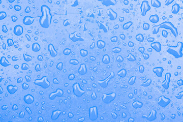 Drops of water on the blue plastic surface. Abstract background