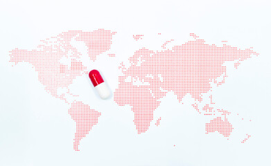 Red capsule medicine on the red dots pattern world map. A novel drug for global pandemic prevention and treatment against infectious diseases © HYUNGKEUN