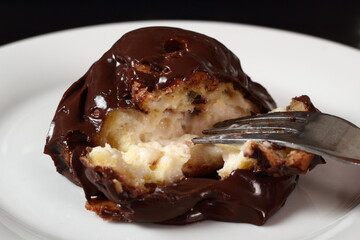 Profiterole with chocolate ganache frosting.  Choux pastry ball with custard filling and chocolate sauce icing.