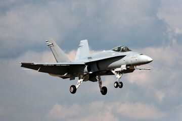 Multirole strike fighter aircraft on approach to land at an airport.