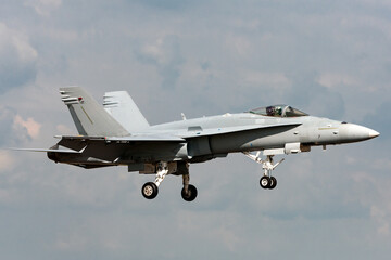 Multirole strike fighter aircraft on approach to land at an airport.