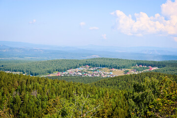 View of agricultural land and pine forests from the Chashkovsky ridge. Ural mountains. Eco-tourism and hiking concept.