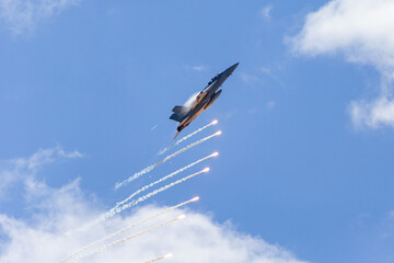 Fighter jet aircraft firing countermeasures flares to avoid missiles.