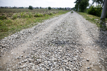 Shallow depth of field (selective focus) image with an unpaved stone road.