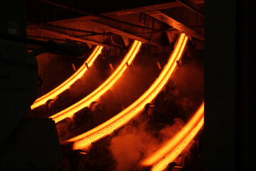 Red hot steel metal billets after molten steel casting.  Continuous casting machine. Background of...