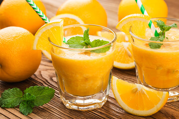glass of fresh orange juice with fresh fruits on wooden table