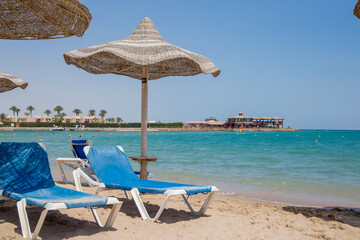 beach with umbrellas and sun loungers by the sea