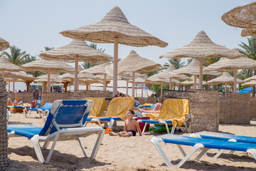 beach with umbrellas and sun loungers by the sea