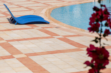 pool with sun loungers with blue water