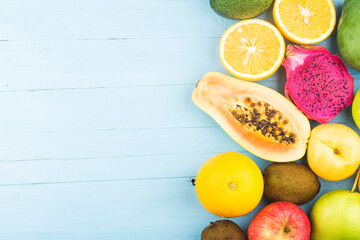 Various fresh fruits on top of blue wooden board background