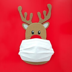 Cardboard cutout of cute reindeer wearing a face mask. Covid during Christmas season concept.