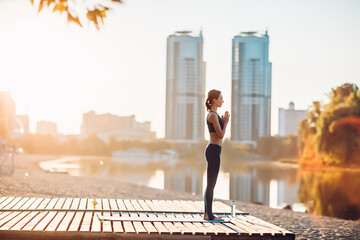 Sportswoman do yoga at sunrise
