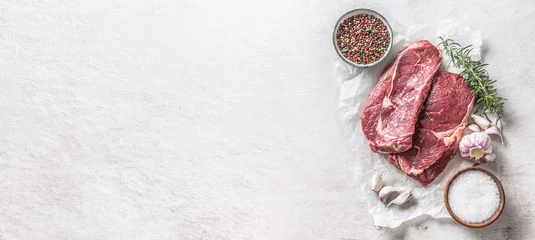  Twee Rib eye steak zout kruiden rozemarijn en knoflook bovenaanzicht. Rundvlees op witte betonnen tafel © weyo