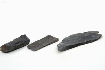 Pieces of shale on a white background. Shale is a fine-grained, clastic sedimentary rock