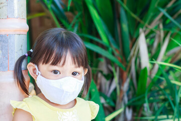 Portrait image of 2-3 yeas old baby. Happy Asian child girl smiling and wearing fabric mask,​ She...