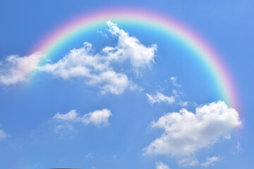 Abstract rainbow on beautiful blue sky and white clouds as background and wallpaper. 