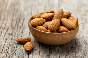 Almonds in Wooden bowl on old wooden table