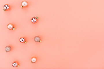 Beautiful Christmas holiday decorations in contemporary trendy orange colors on coral background. Flat lay, copy space, top view. Winter holidays, New Year. Merry Christmas card. Horizontal border ban