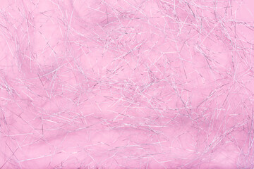 Fototapeta premium Glitter shreds. Sparkling shiny paper texture for Christmas. Silver shreds on pink background. Flat lay, copy space, top view. Winter holidays, New Year. Merry Christmas card. Space for text.