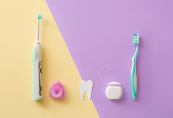 Tooth brushes and floss on color background