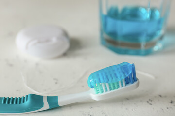 Tooth brush, floss and mouth rinse on table