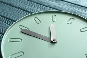 Simple clock on wooden background, closeup