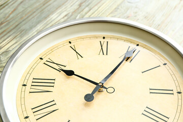 Simple clock on wooden background, closeup