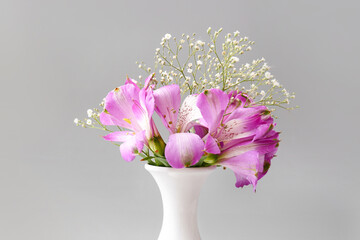 Beautiful vase with flowers on grey background