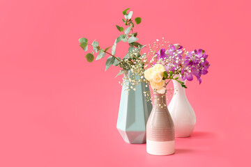 Beautiful vases with flowers on color background