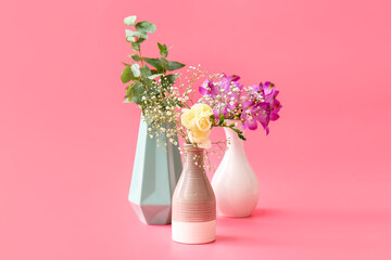 Beautiful vases with flowers on color background