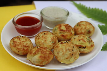Appum or Appe, Appam or Mixed dal or Rava Appe served with green and red chutney. A Ball shape popular south Indian breakfast dish, Selective focus
