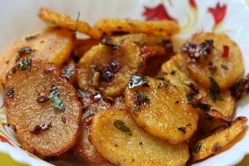 Aloo Katli or Potato Katli is an excellent and tasty asian dish, slices of fried potatoes, sauces and herbs, snack or starter 