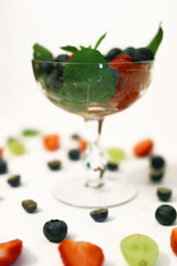 berry cocktail in a crystal glass with strawberries, blueberries, blueberries and mint close up