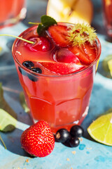 Drink with slices of apples, strawberry, currant and lime