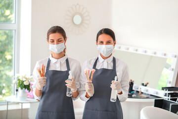 Female makeup artists wearing medical masks in salon during coronavirus epidemic