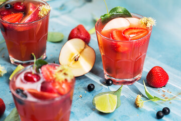 Red cocktails with berries, strawberries, currant and apple
