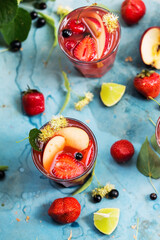 Two cocktails with strawberries, currant, apple, berries