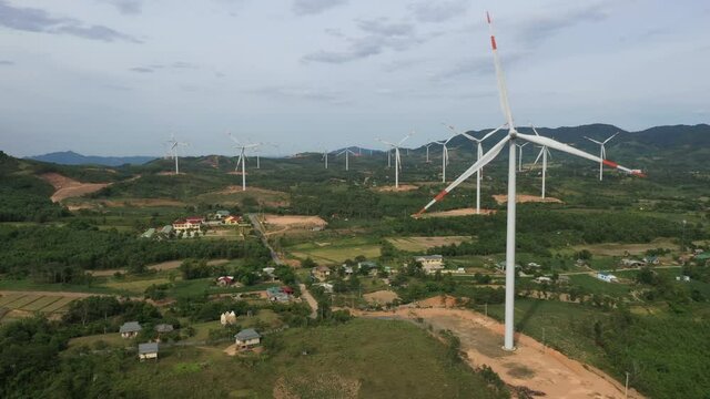 Aerial view of windmills farm for energy production on rice field, Huong Linh, Quang Tri, Vietnam. Wind power turbines generating clean renewable energy for sustainable development