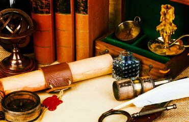 Old books, feather pen and ink bottle, old scroll with red wax seal, vintage compass. Adventure stories background.