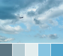 Beautiful dramatic gray and white clouds on light blue sky and a silhouette of airplane. Color palette swatches, natural combination of colors in the blue gamma.