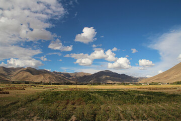 Autumn view of Tibetan Village and highland barley field in cloudy day, Tibet, China