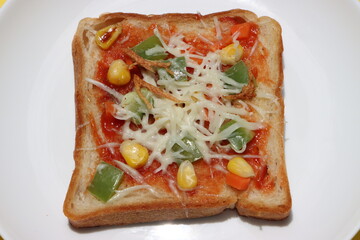 Brown bread pizza, topped with sweet corn, vegetables and cheese, kids breakfast, Indian street food 