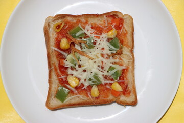 Brown bread pizza, topped with sweet corn, vegetables and cheese, kids breakfast, Indian street food 