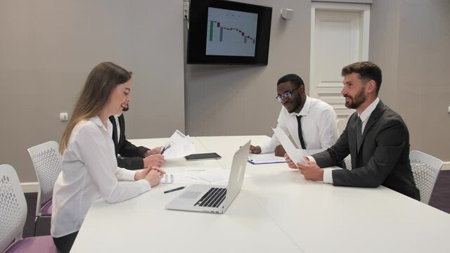 Business negotiations of multiethnic colleagues concerning a new startup. The concept of teamwork Profit return chart.