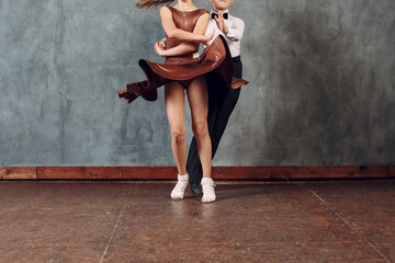 Fototapeta na wymiar Young dancers boy and girl dancing in ballroom dance Samba. Close up legs