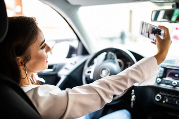 Beautiful young woman take selfie on driver seat in car. Travel journey lifestyle concept