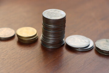 Coins stacked on wooden background, business or finance concept 